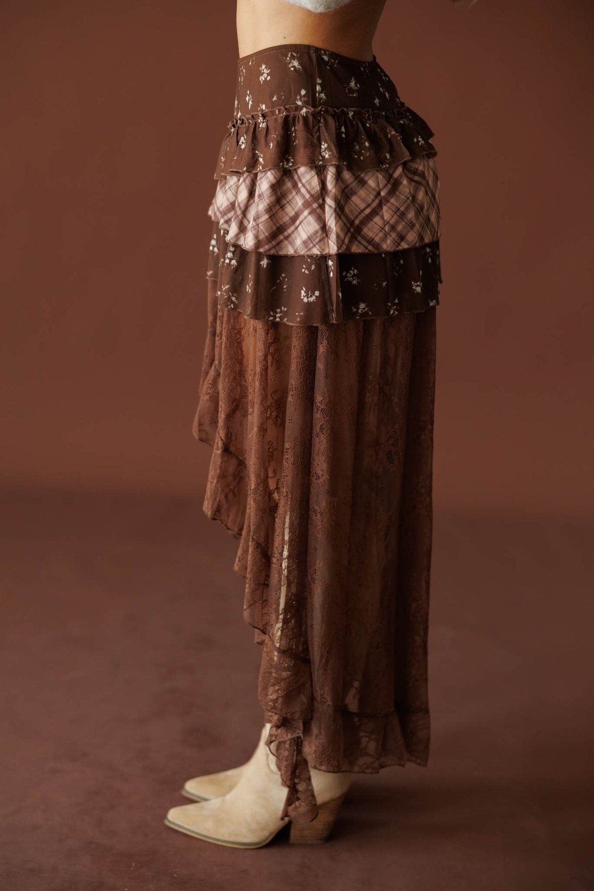 The Storyteller Skirt in brown, side view showing the high low lace hem