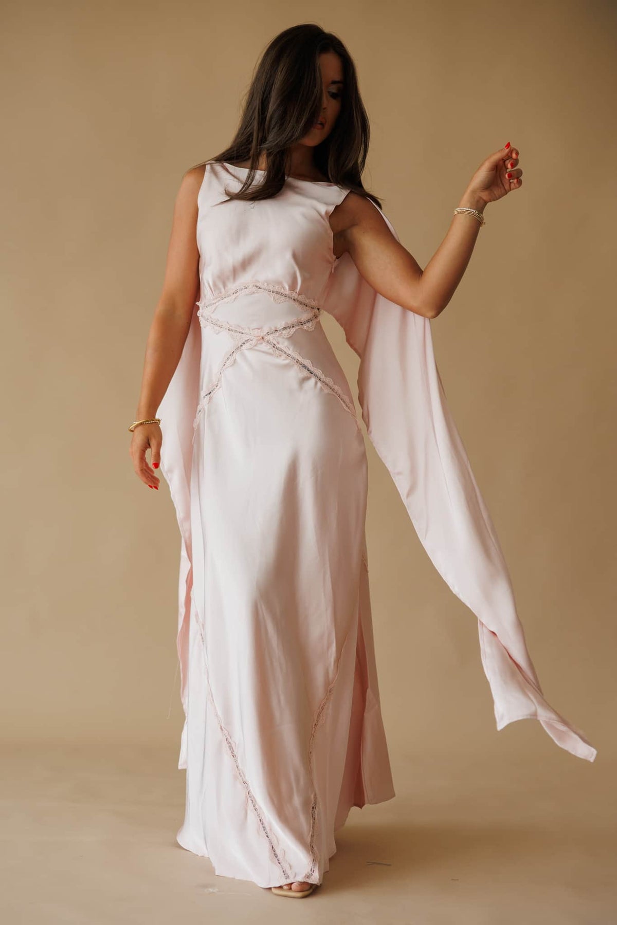 Chasing Forever Dress in dusty pink, full-length front view on model holding the draped sash