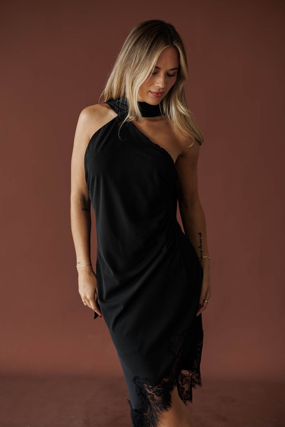 Three-quarter front view of the scarf tie halter neckline on the black midi dress