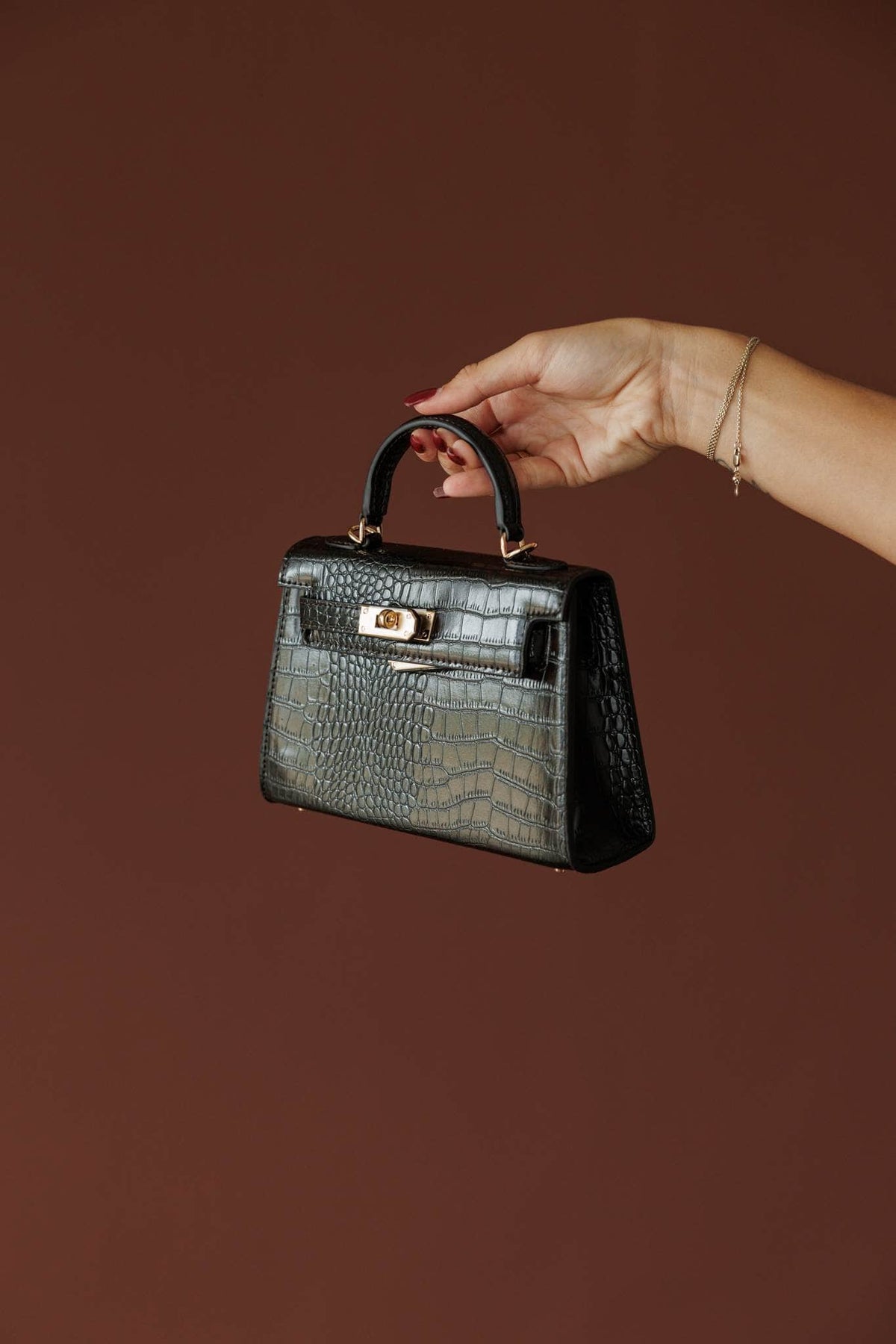Hariette Handle Bag***, in dark cacao, three-quarter view of the mini bag held by the handle