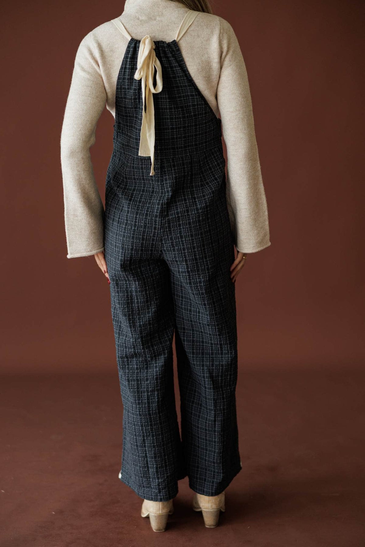 Field Trip Overalls in black plaid, back view of the straps and wide leg