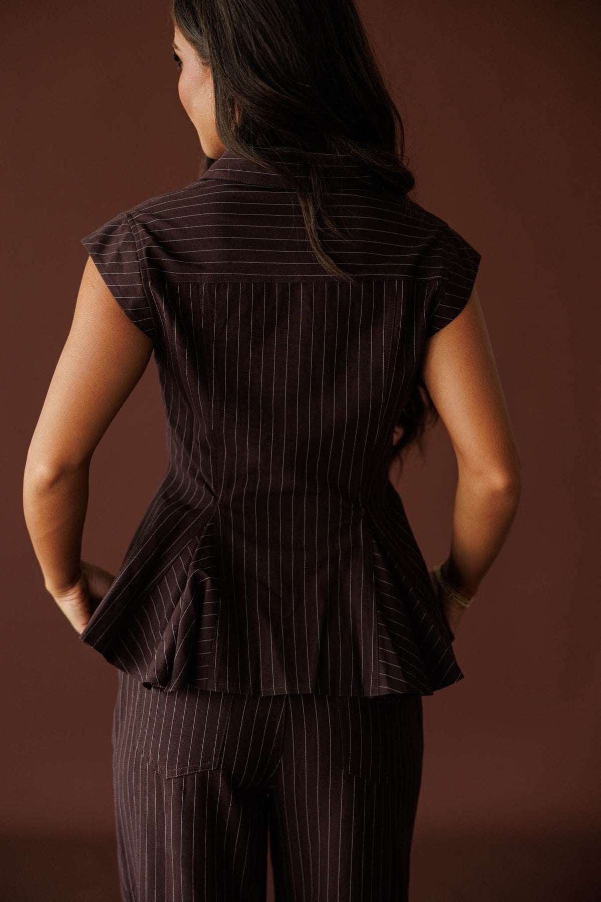 Members Only Top in brown pinstripe, back view showing the cap sleeves and flared back