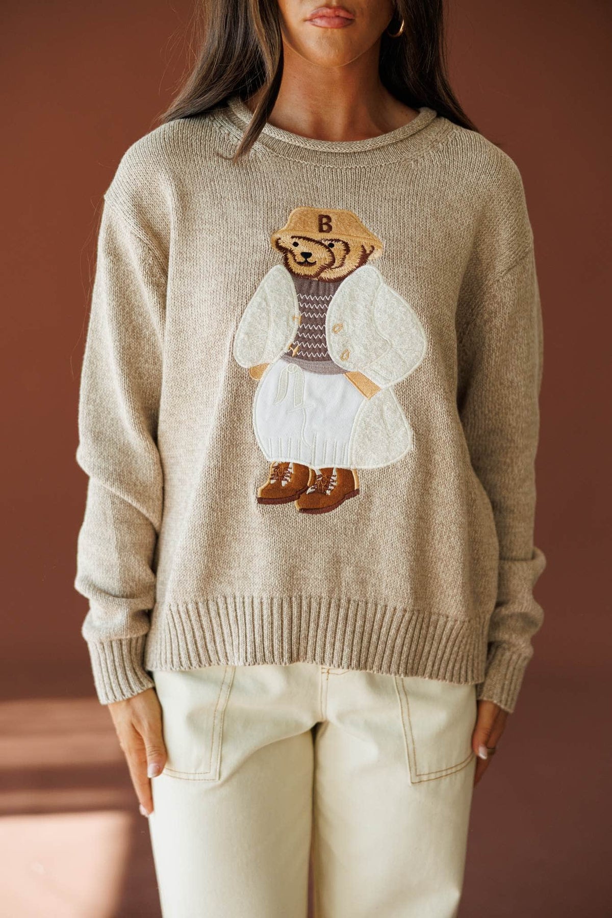 Manhattan Teddy Sweater in taupe, front close-up of the knitted teddy bear motif