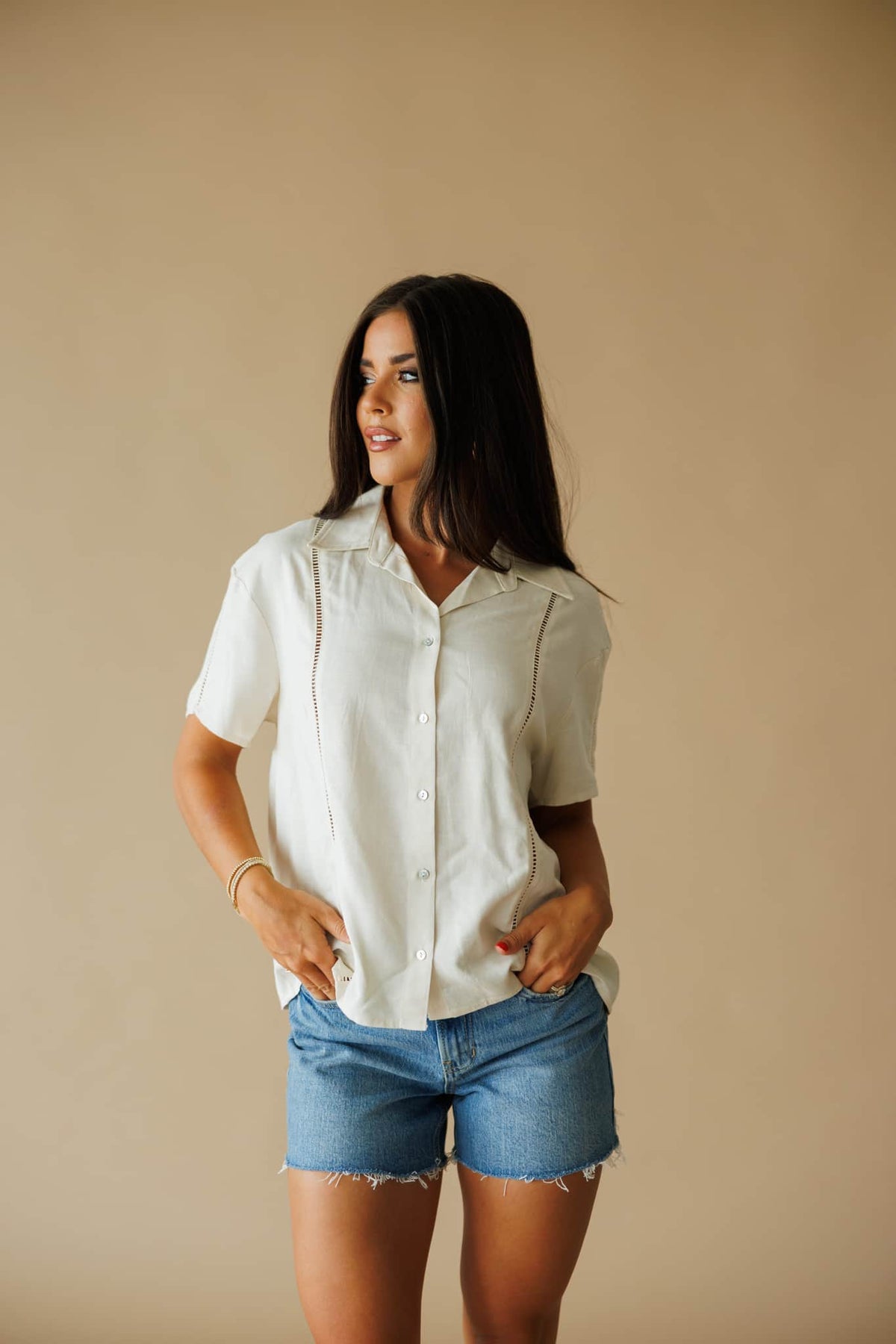 The Coastline Shirt in cream, full-length view with light wash denim shorts
