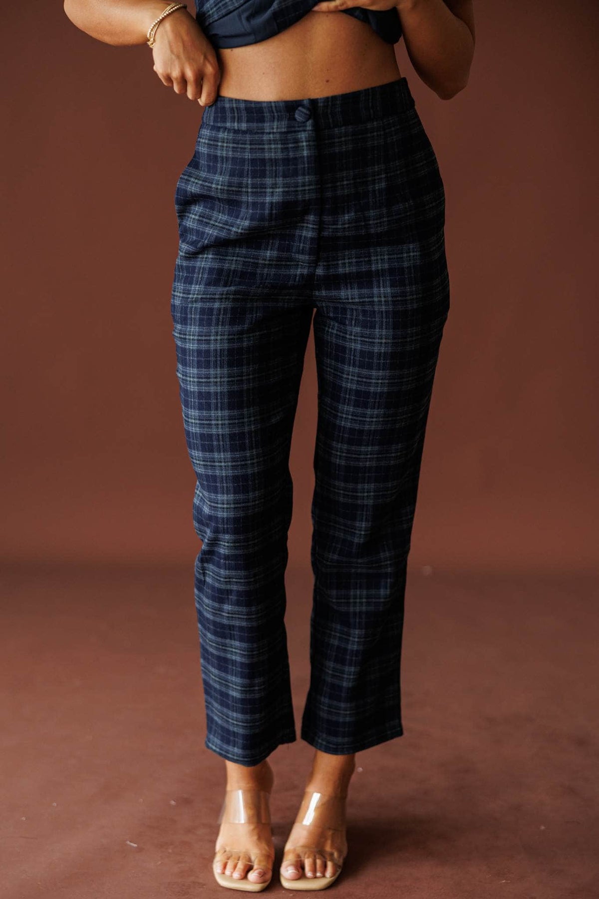 The Socialite Pants in teal plaid, front view of the straight leg with heeled sandals
