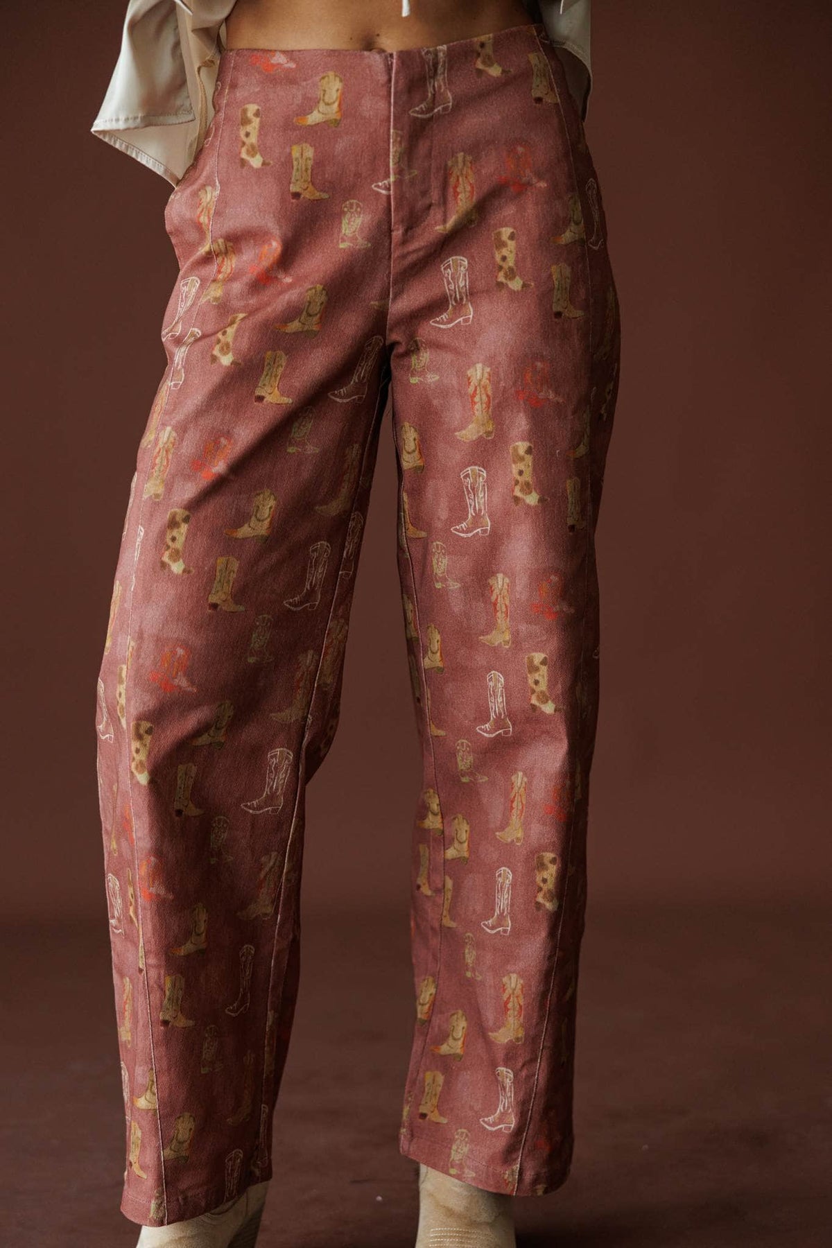 Rodeo Road Printed Pants in brick red, front close-up of the boot print and high rise waist