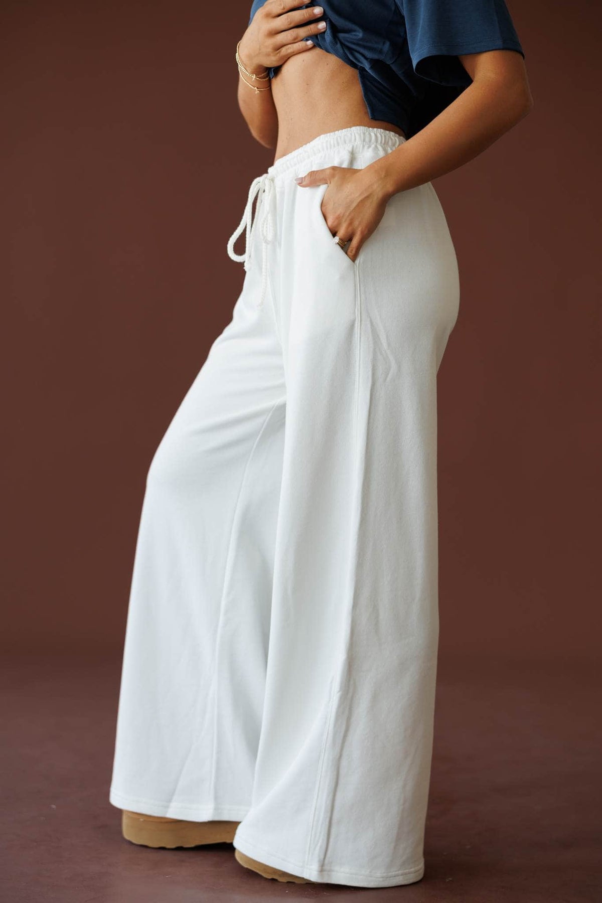 Sideline Wide Leg Pants in off white, side view with one hand in the pocket