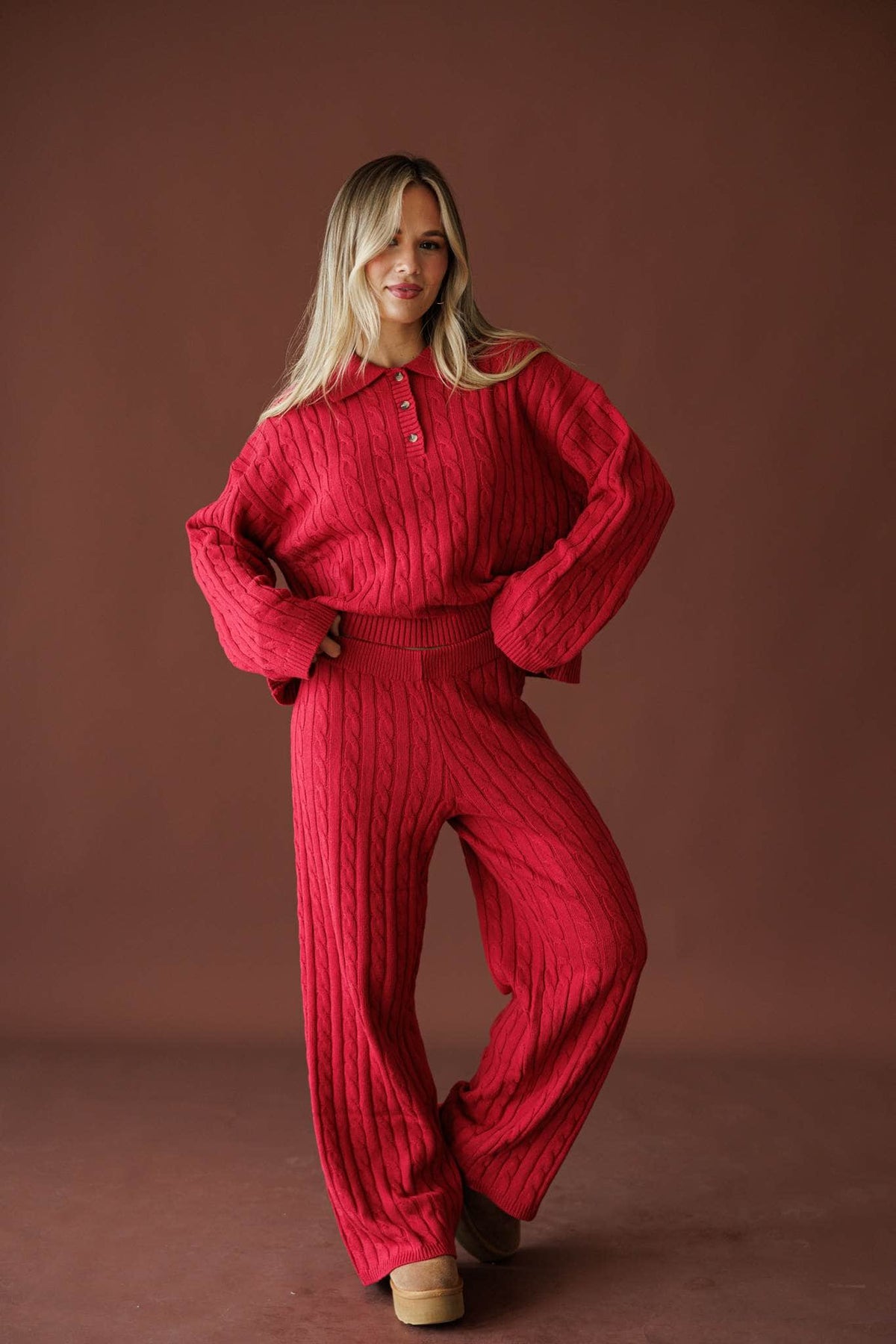 Cherry Cable Knit Sweater in red, full-length view on model with a hand on the hip