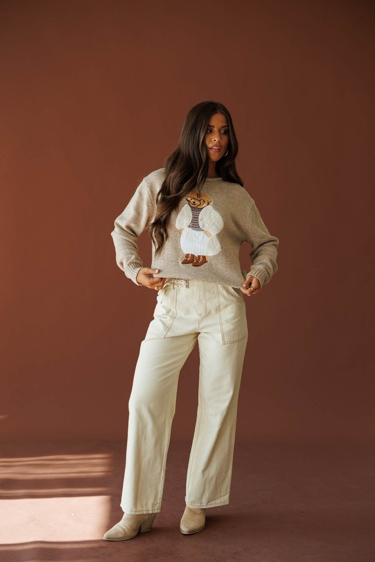 Buckle Point Pants in taupe, full-length view with a cream graphic sweatshirt
