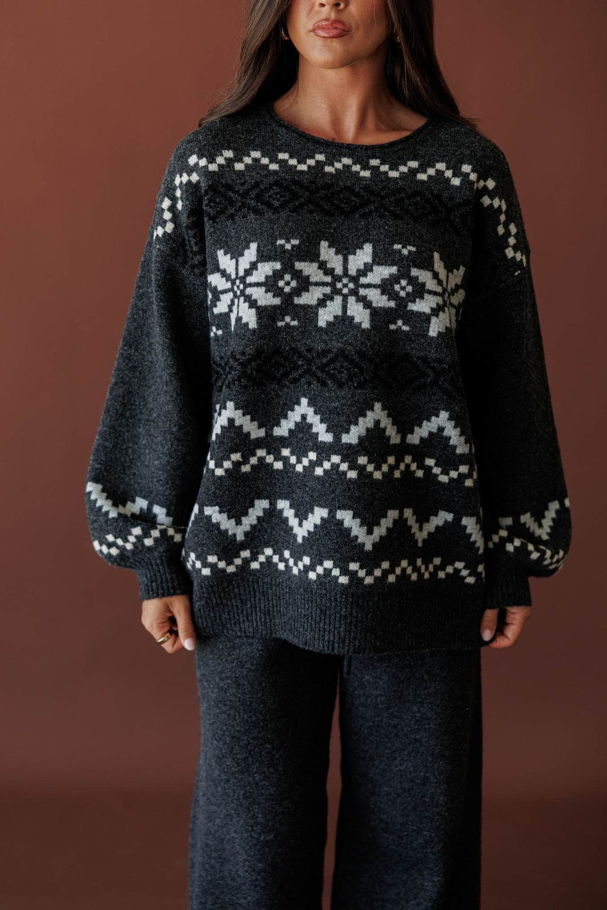 Cabin Cozy Sweater, in charcoal, front view of the snowflake pattern and rolled collar