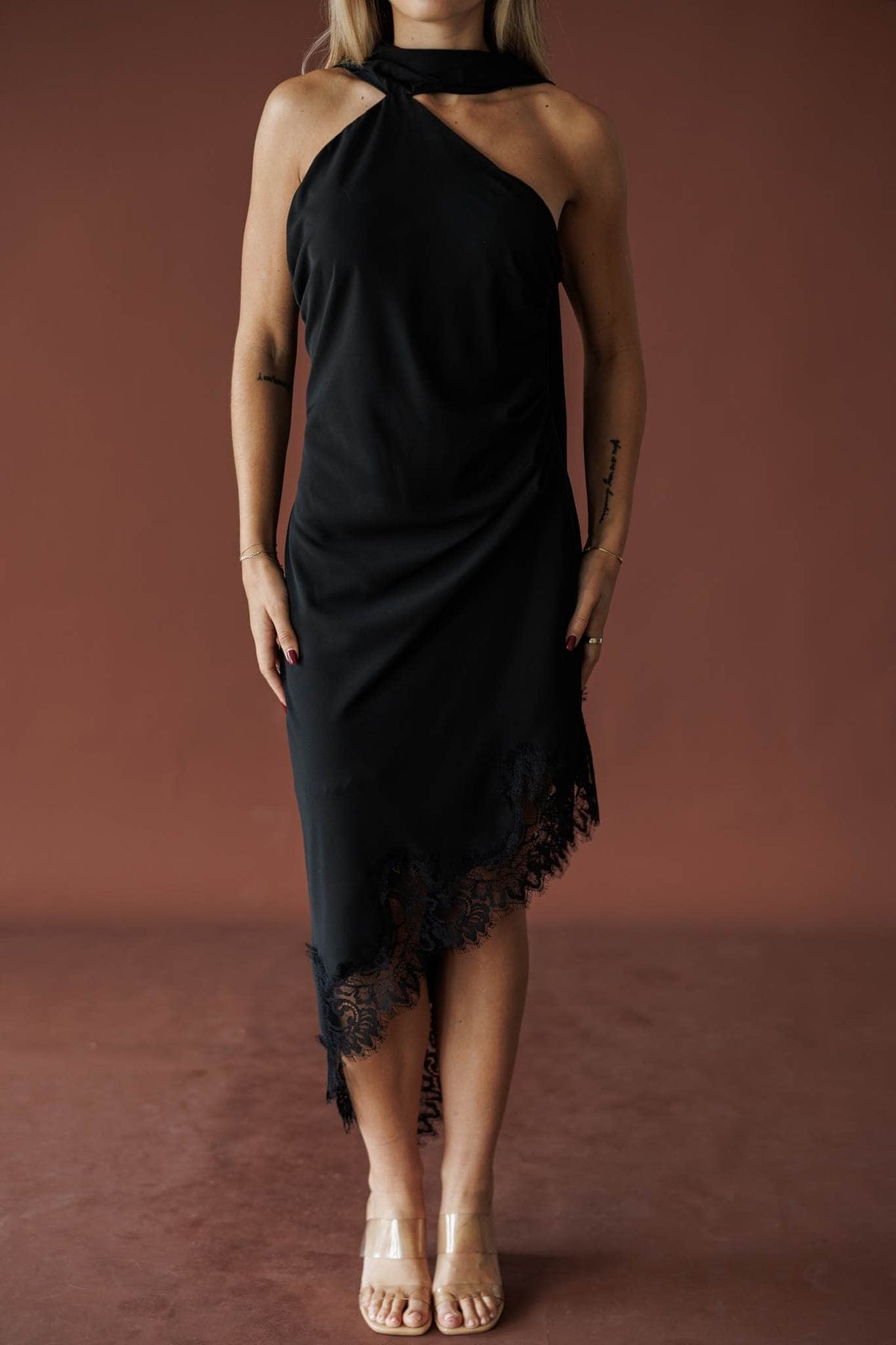 Front view of the asymmetric eyelash lace hem on the black midi dress