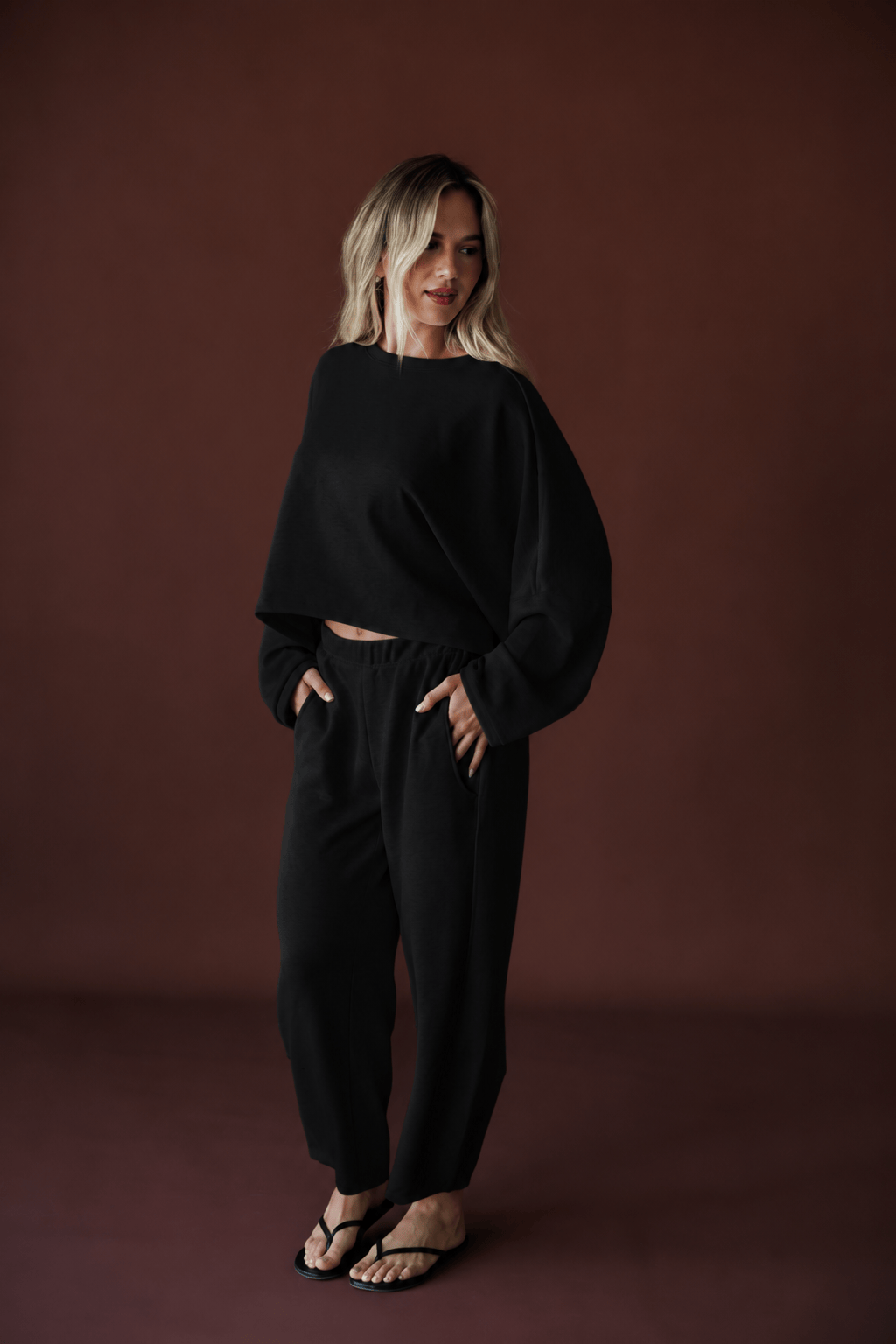 Cropped Scuba Dolman Top in black, full-length view on model with hands in pockets