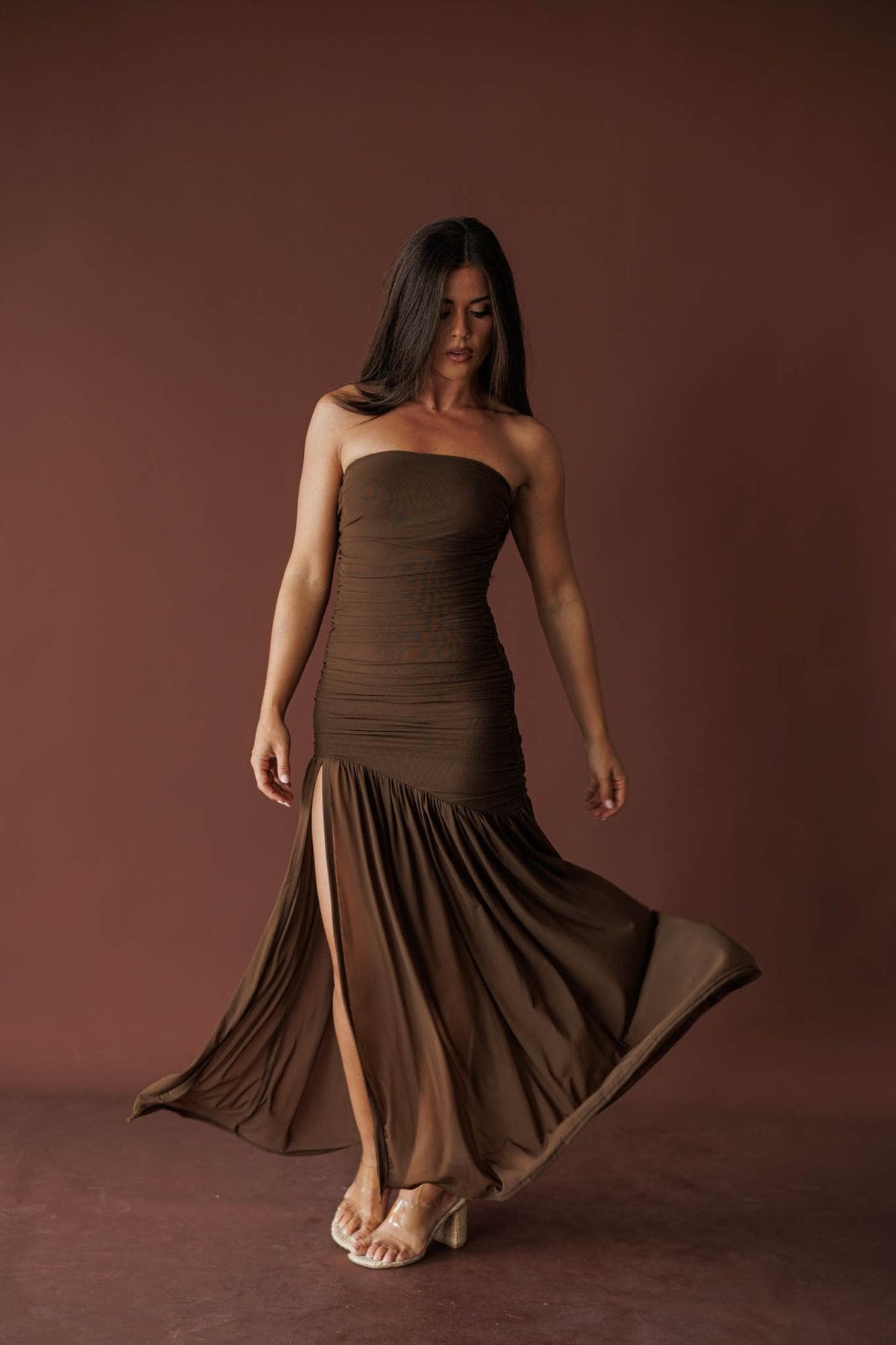 Allison wearing the mocha Dark Roast ruched strapless maxi dress, full-length front view with the skirt in motion