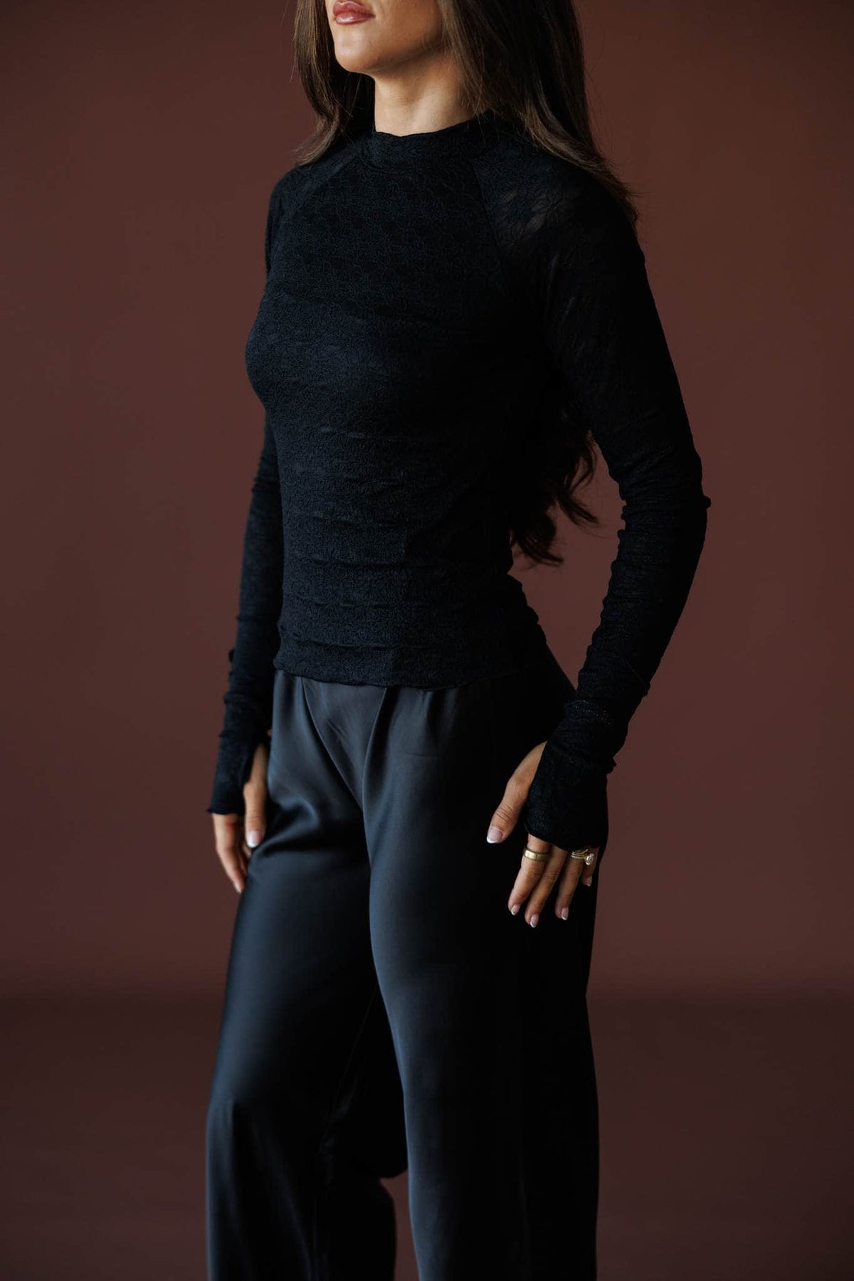 Delicate Matter Lace Top in black, front view on model with hands at the waist