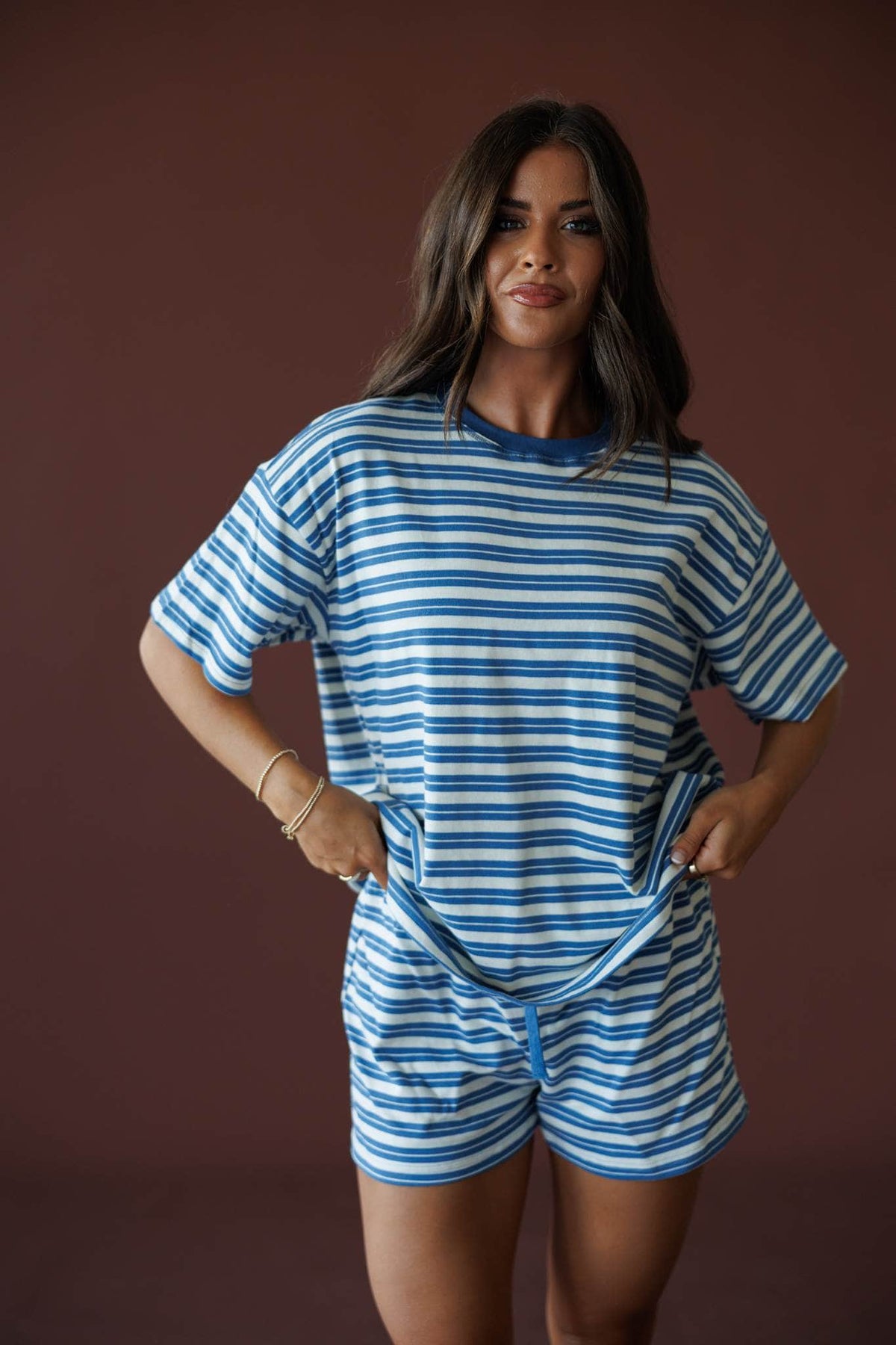 Doing Things Tee in dusty blue, front view on model with hands at the waist