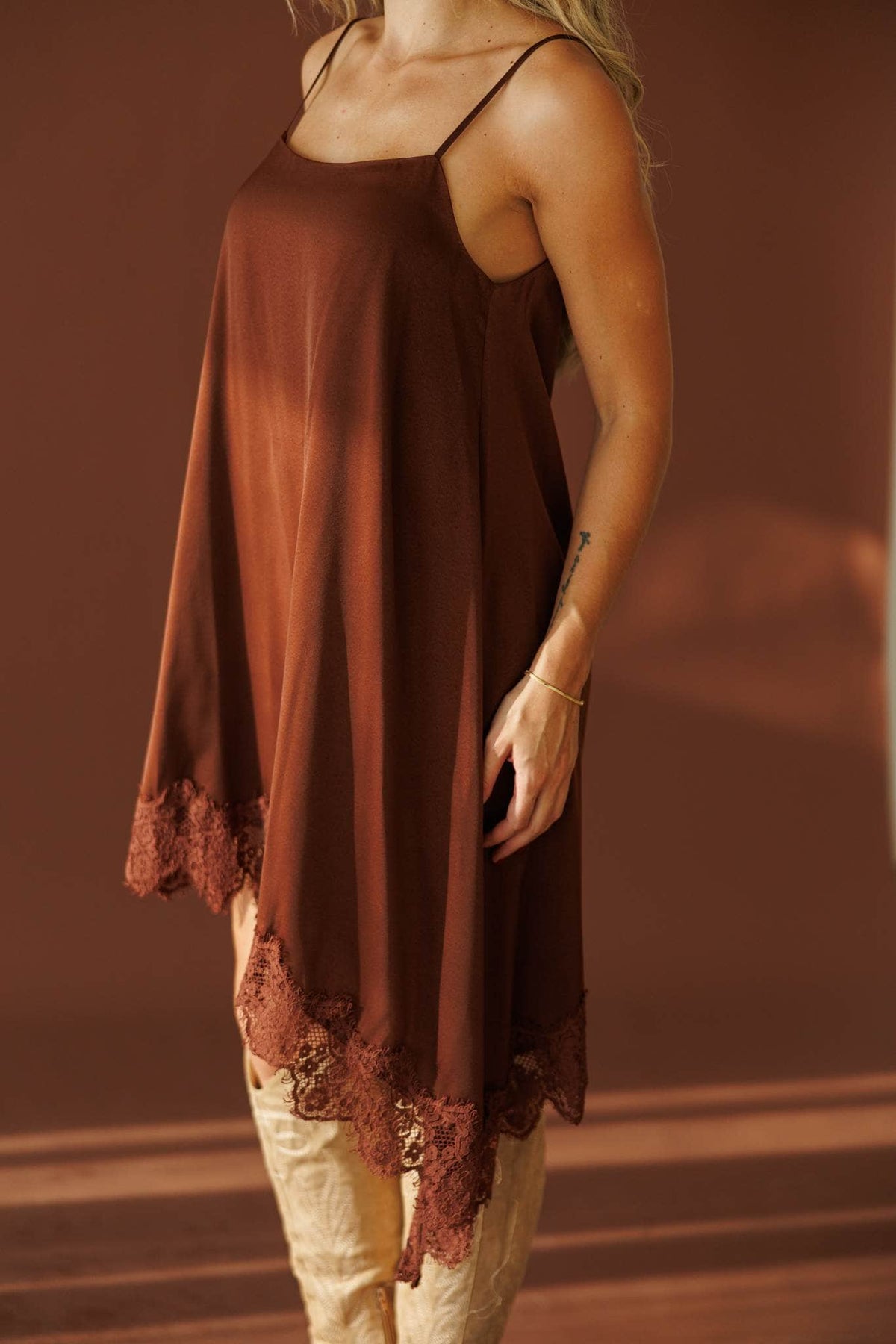 Evening Notes Lace Dress in brown, side close-up of the satin slip and lace hem