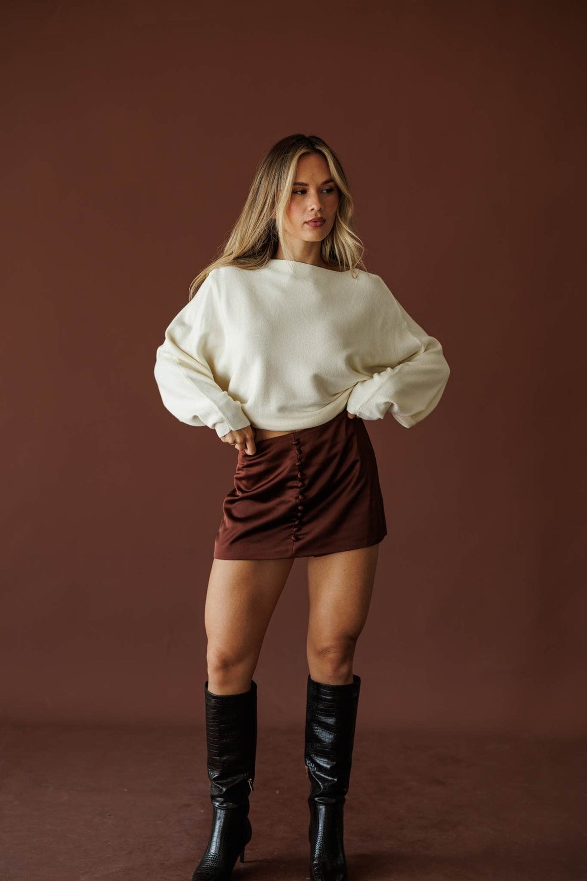 Button Up Satin Skort, in crimson brown, three-quarter front view with a cream sweater