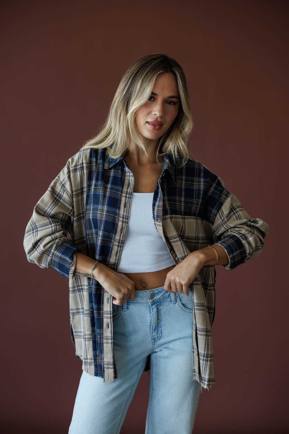 Harvest Club Plaid Top in sand and midnight, front view on model with hand at the waist