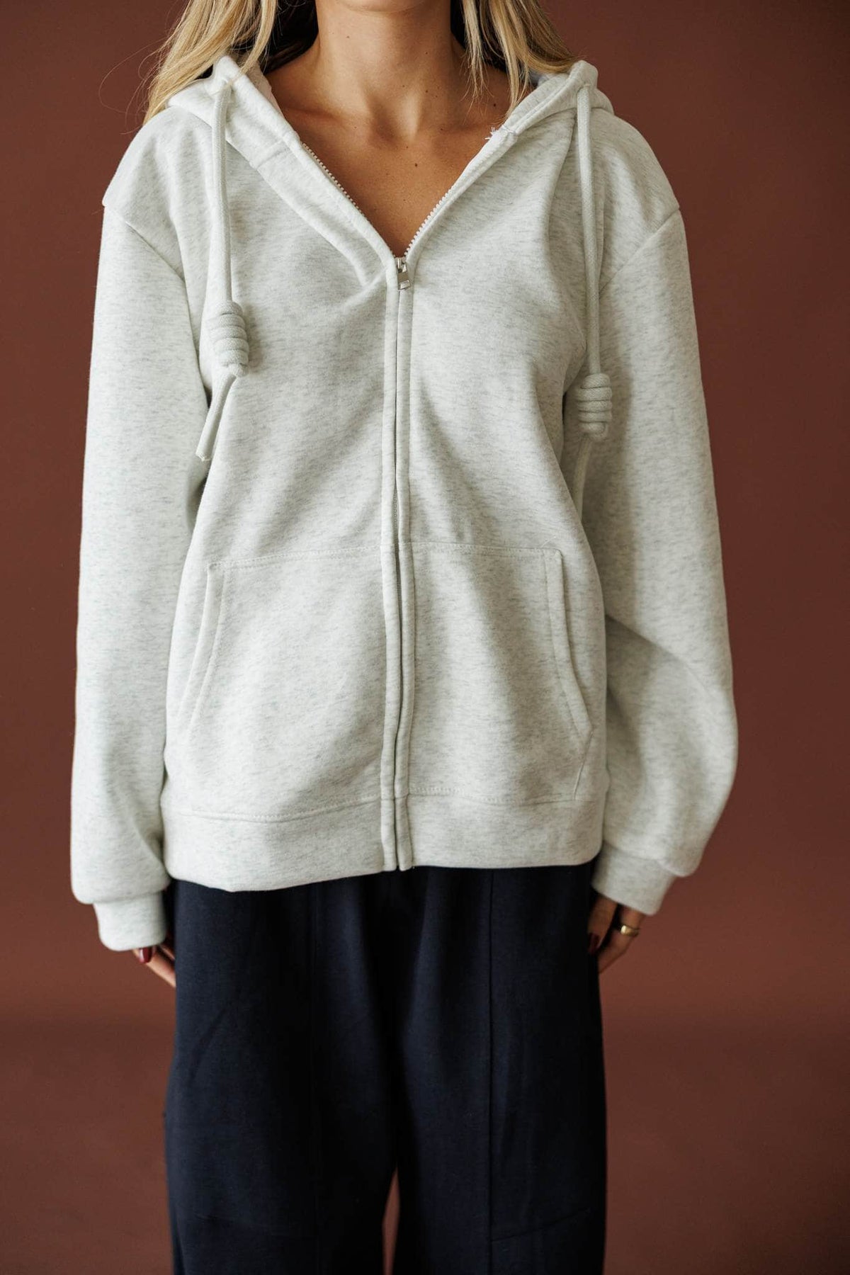 On Standby Zip Up Jacket in light heather grey, front view of the full zip and drawcord hood