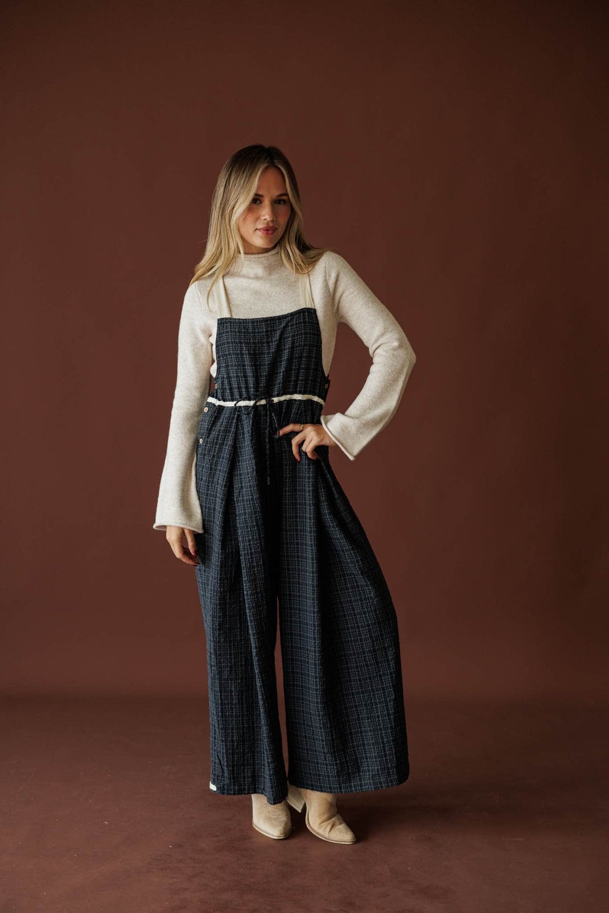 Field Trip Overalls in black plaid, full-length view over a cream long-sleeve top