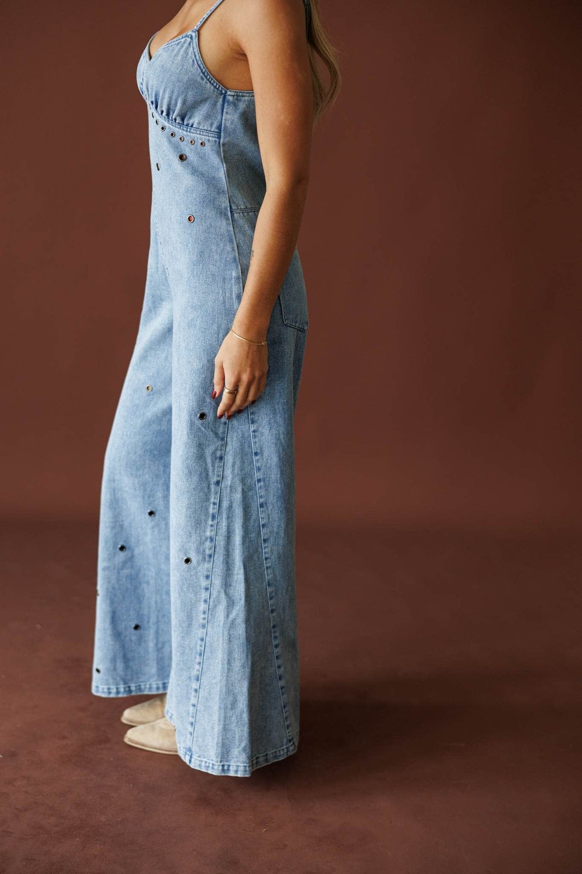 Motel Rodeo Denim Jumpsuit in light denim, side view showing the wide-leg silhouette
