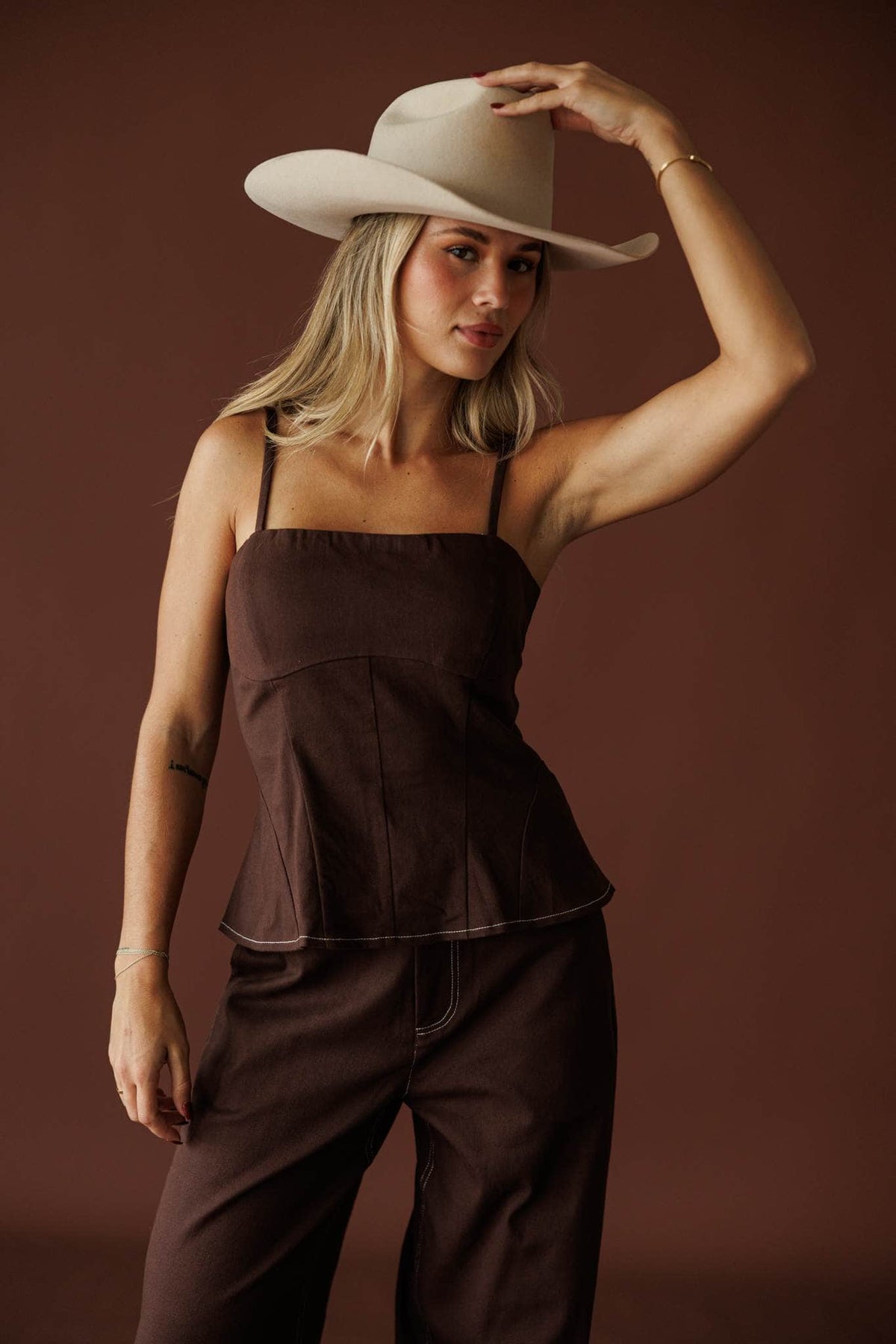 Roadhouse Peplum Top in brown, full-length view with the matching barrel pants and cowboy hat