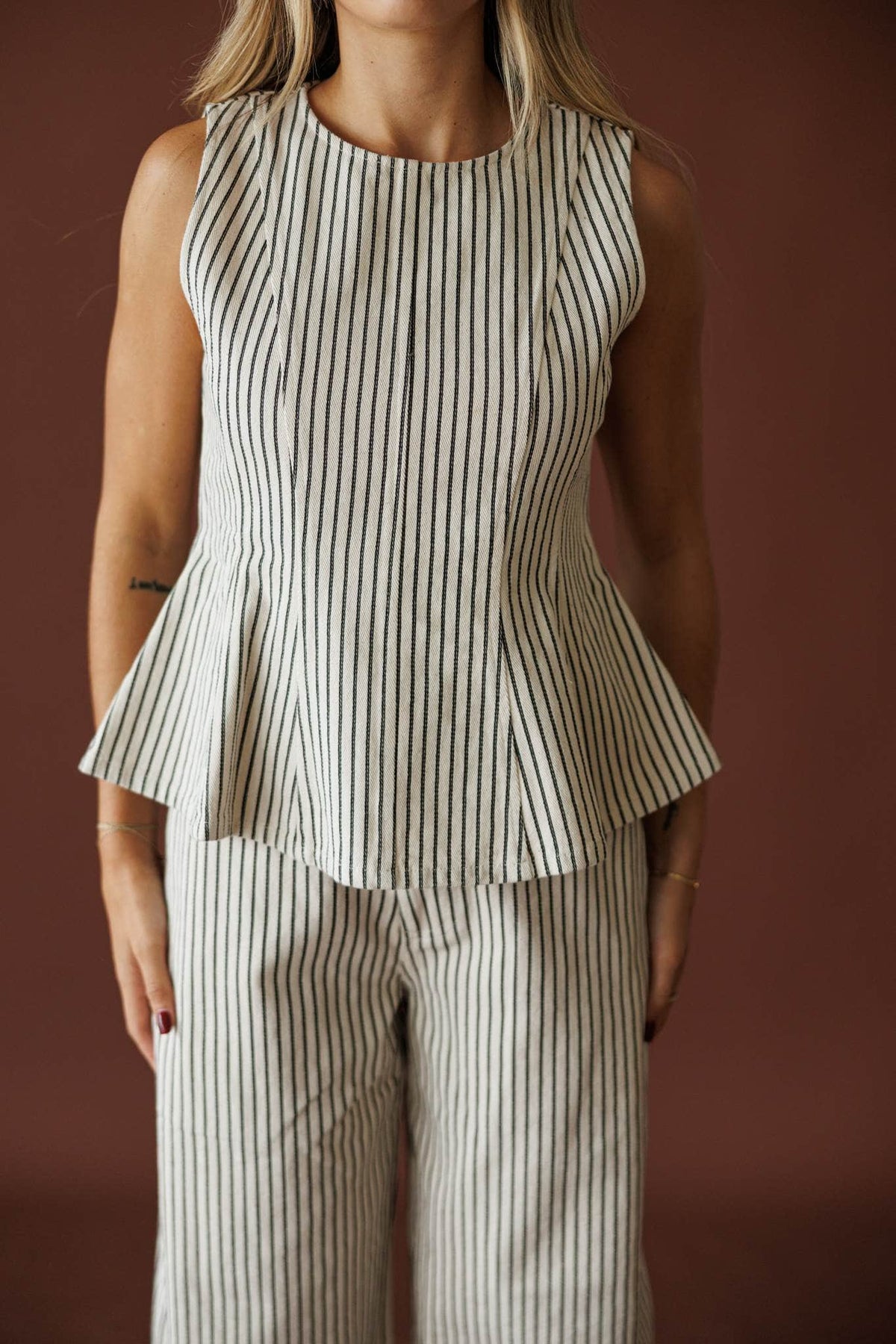 Day In The City Top in natural pinstripe, front view of the sleeveless peplum bodice