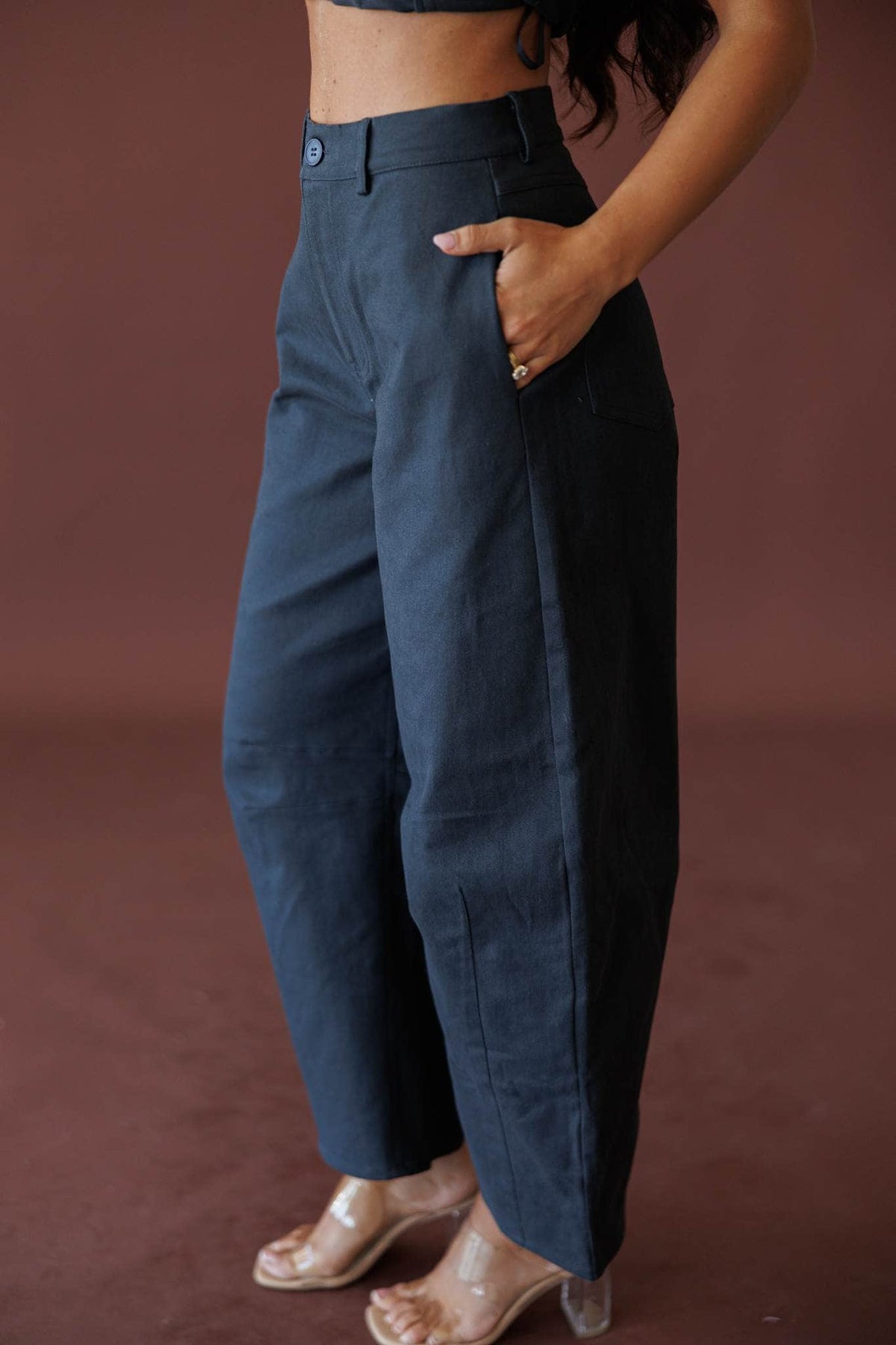 The Regent Barrel Pants, in navy, side view with hands in pockets