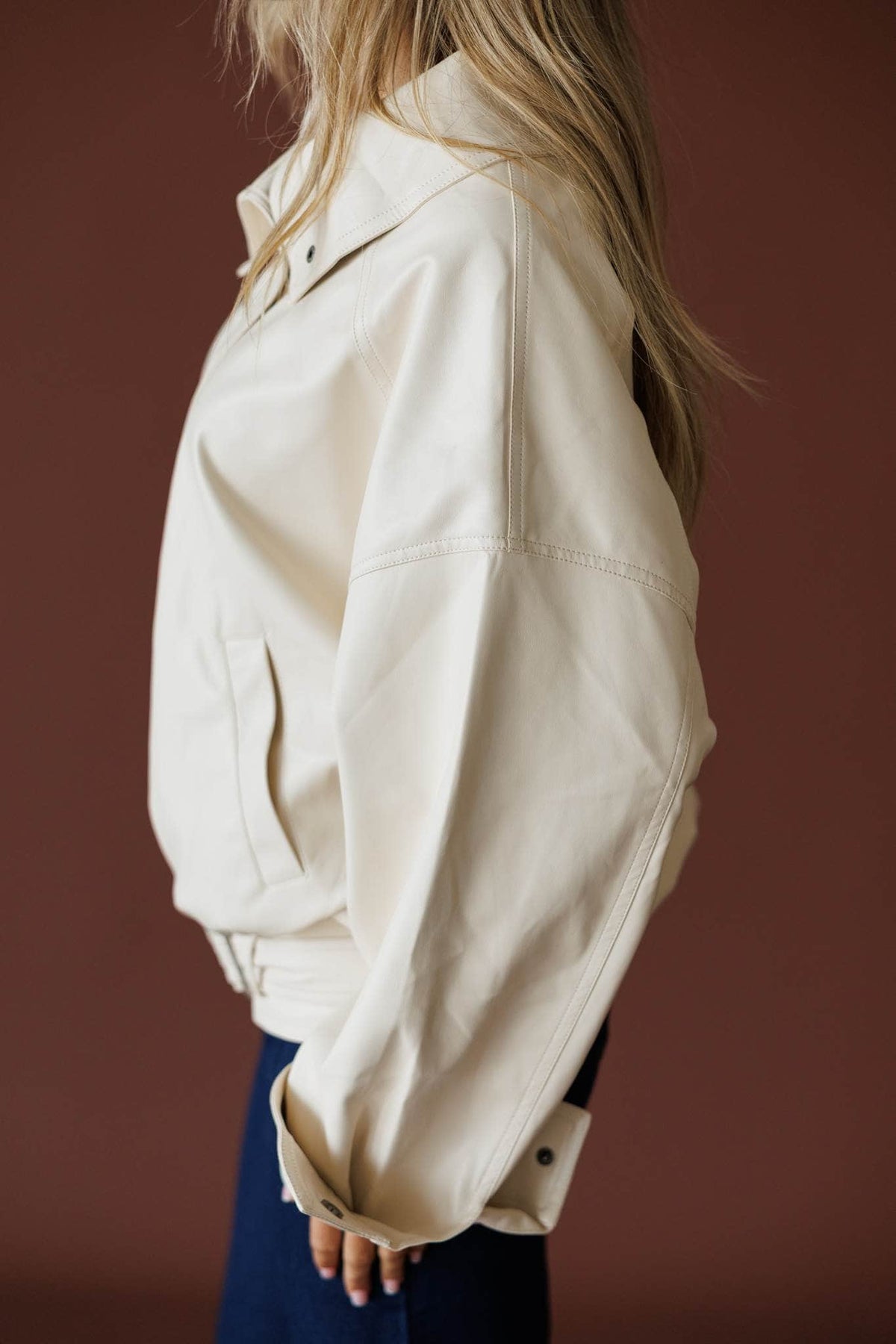 The Waypoint Jacket in cream, side view showing the slouchy sleeve and belted hem