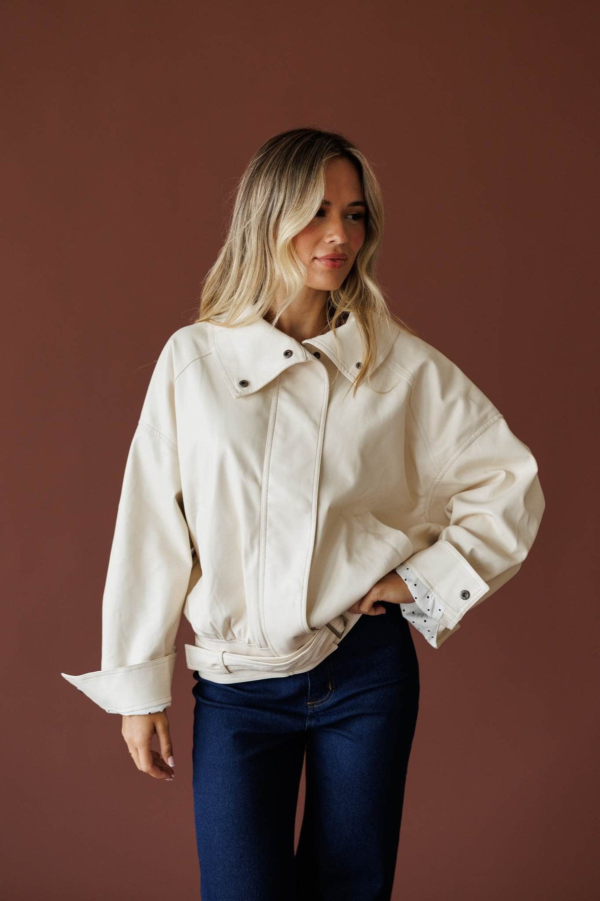 The Waypoint Jacket in cream, full-length view with dark wash jeans