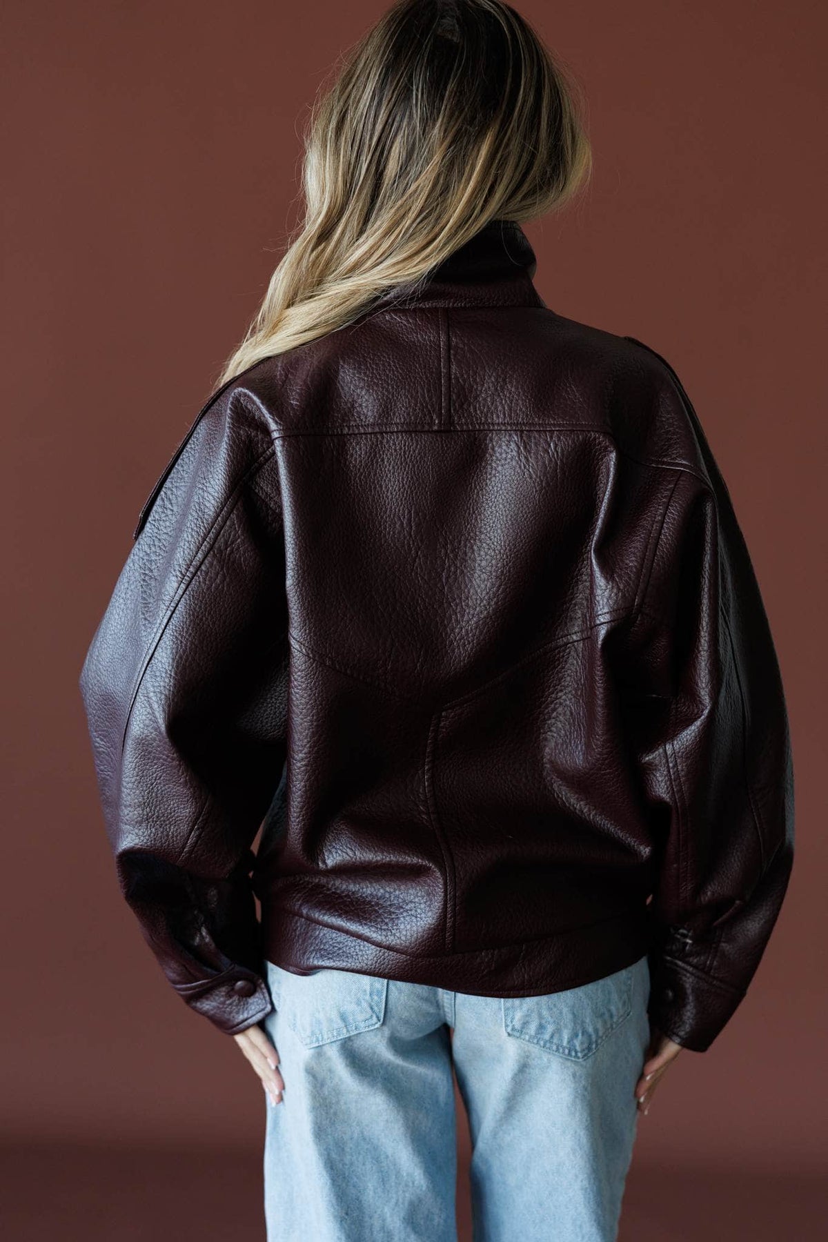 Unlisted Leather Jacket in burgundy, back view showing the oversized leather jacket