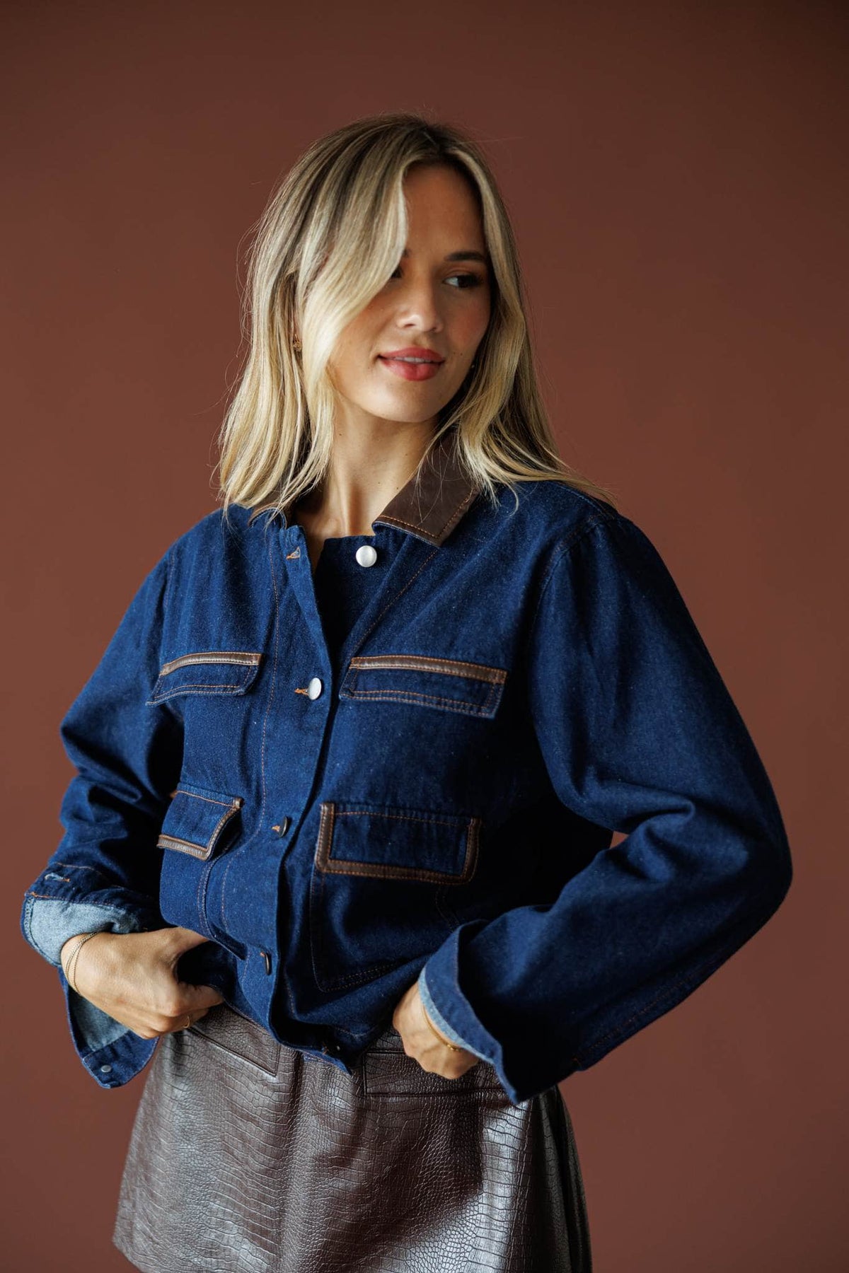On Location Denim Jacket in medium denim, front view on model with hands at the waist