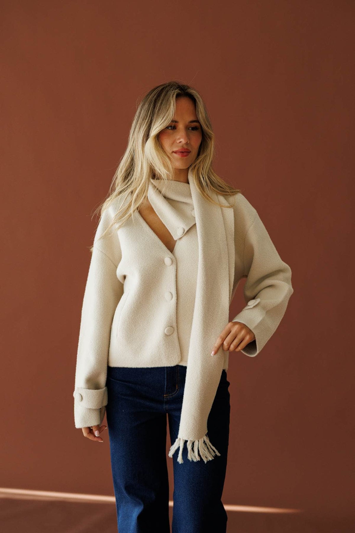 November in New York Sweater in beige, full-length view with dark wash jeans