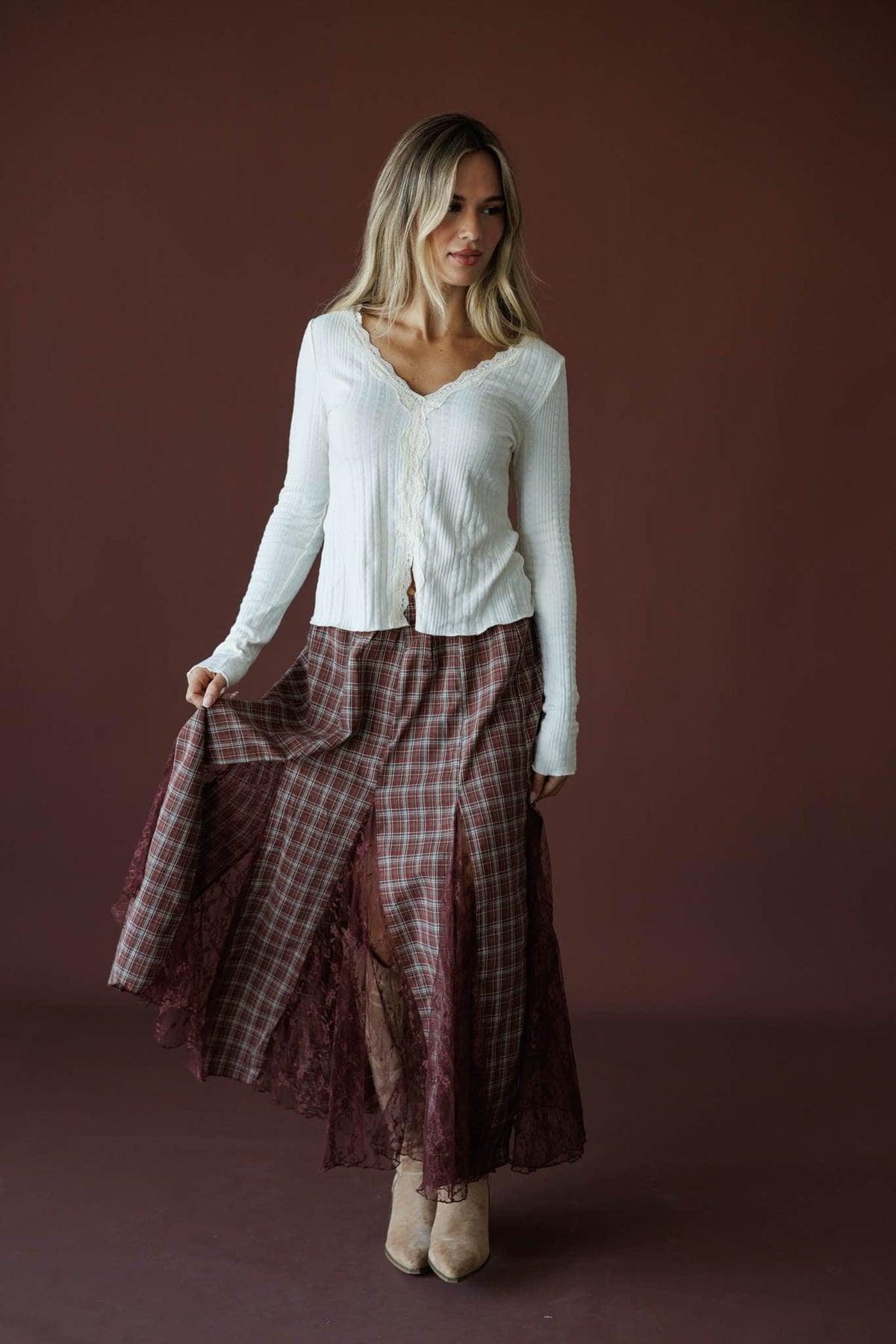 November Novel Plaid Skirt in mulberry, full-length view on model holding the skirt