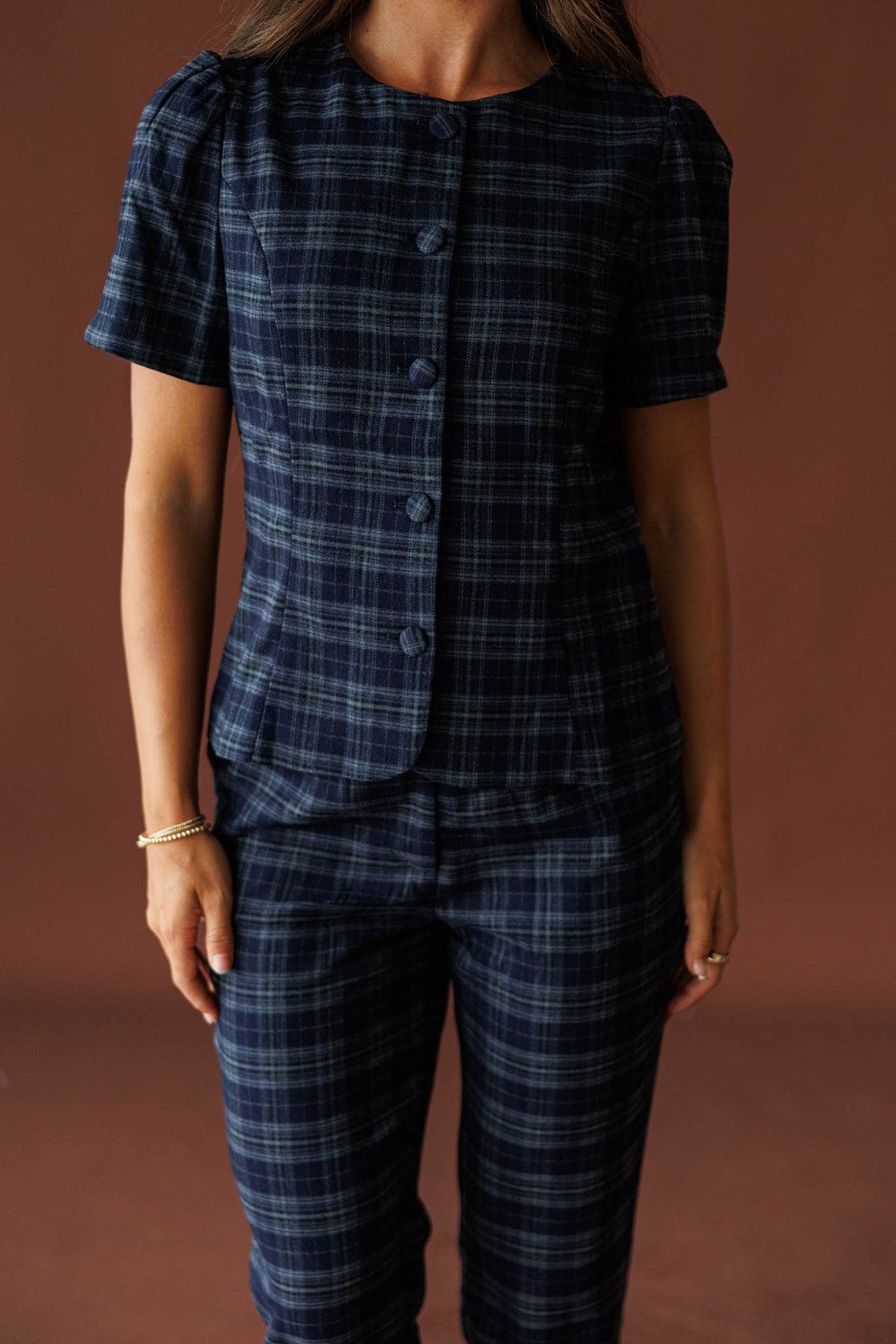 The Socialite Top in teal plaid, front view of the button placket and short sleeves