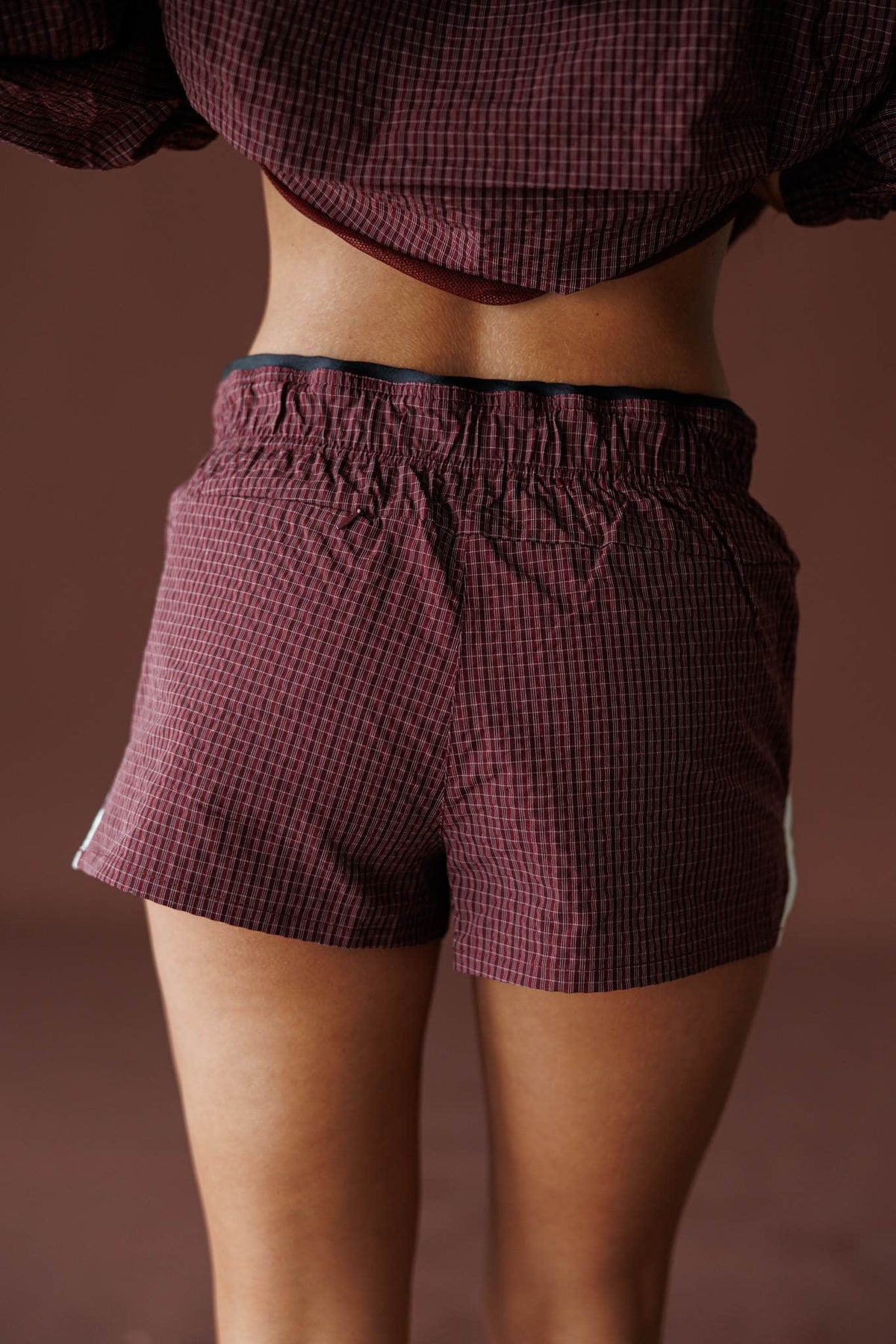 Off Duty Track Shorts in burgundy, back view showing the waffle nylon track shorts