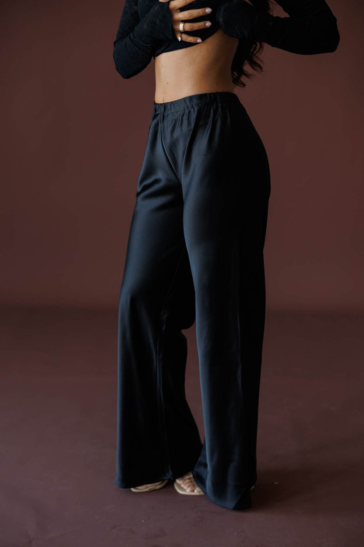 Satin State Pants in black, side view showing the flowing satin wide leg