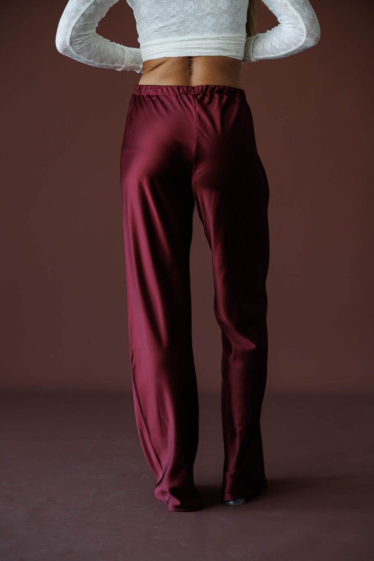 Satin State Pants in mulberry, back view showing the elastic waist and wide leg