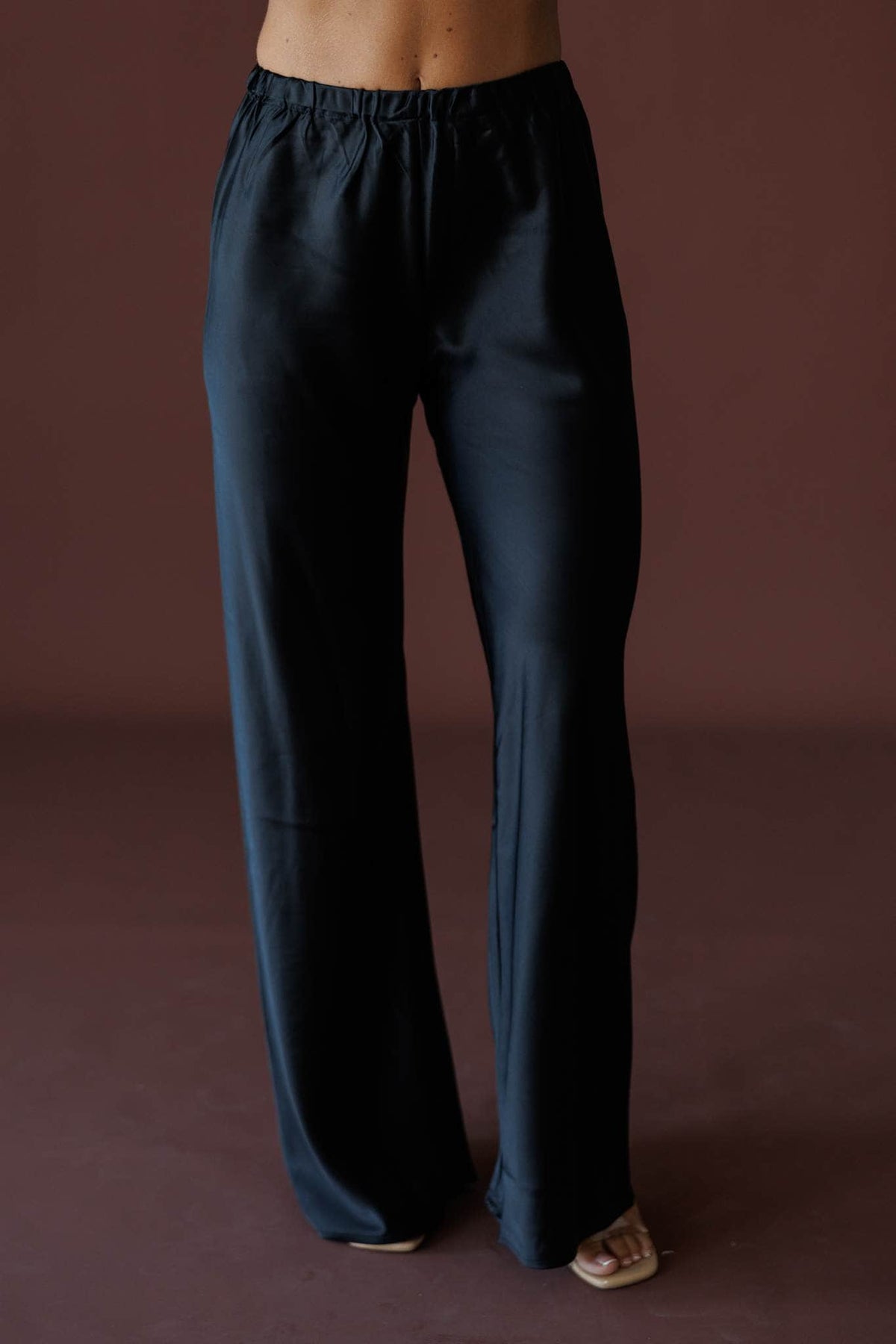 Satin State Pants in black, front close-up of the elastic waist and satin wide leg