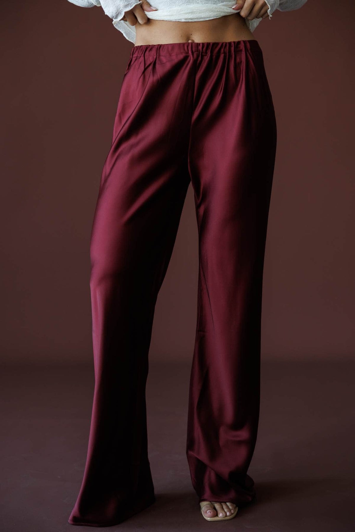 Satin State Pants in mulberry, front close-up of the elastic waist and satin wide leg