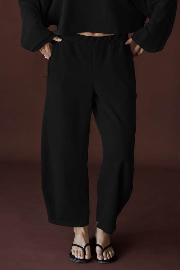 Scuba Barrel Sweatpants in black, front close-up with hands at the waistband