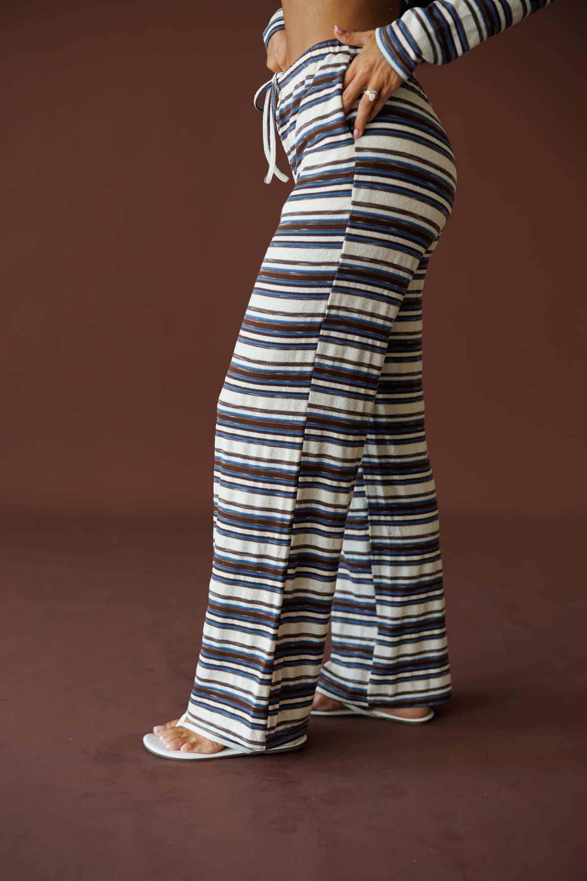 Slow Mornings Pant in blue brown stripe, side view with one hand in the pocket