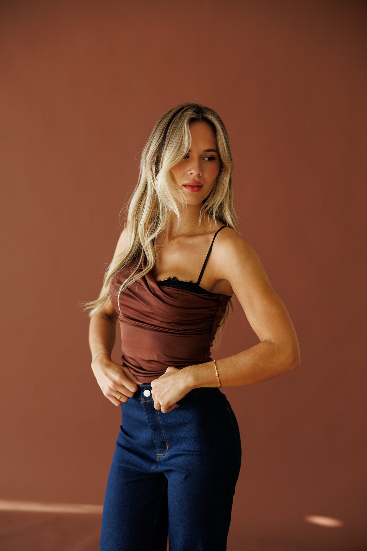 Street Stories Top in brown, front view on model with hands at the waist