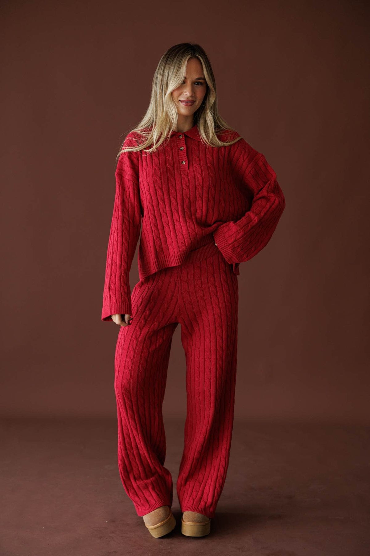 Cherry Cable Knit Pants in red, front view on model with hands at the sides