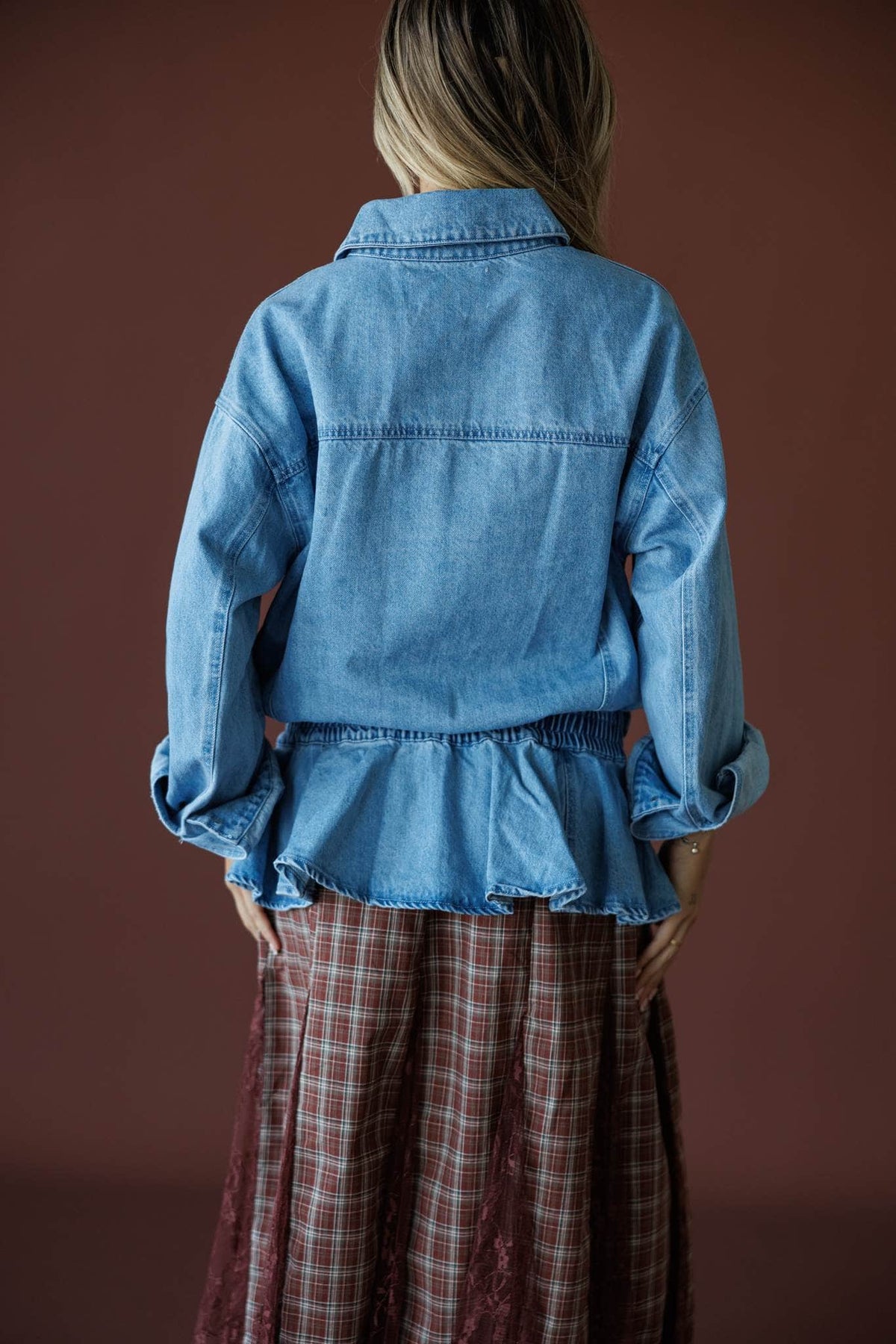 The Remix Denim Jacket in denim blue, back view showing the gathered peplum hem