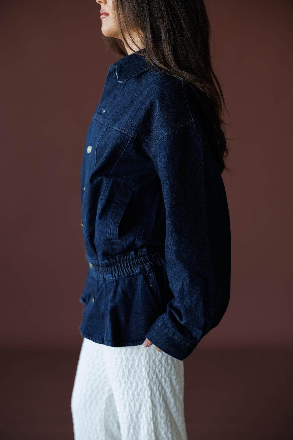 The Remix Denim Jacket in dark denim, side view showing the collar and cuffed sleeve